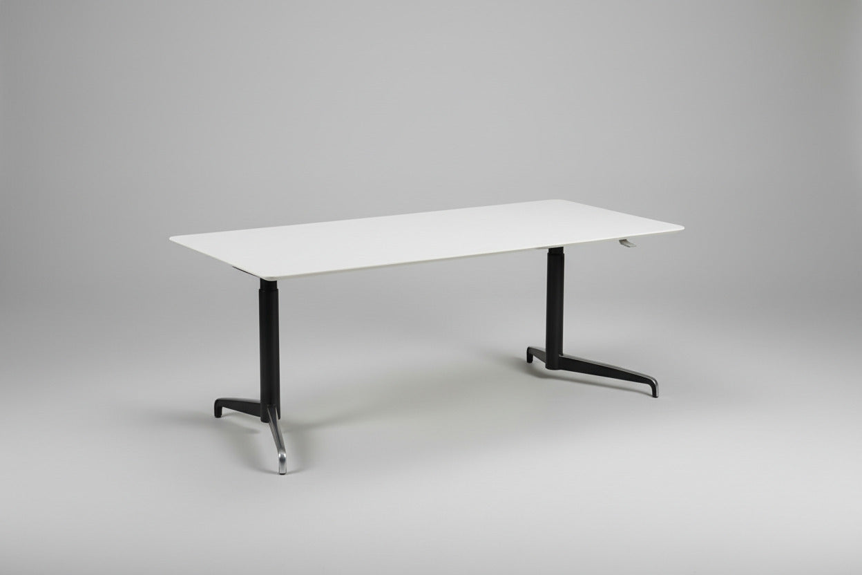 Holmris Genese hæve-sænkebord 180x90 set fra skrå vinkel med hvid bordplade og sort stel